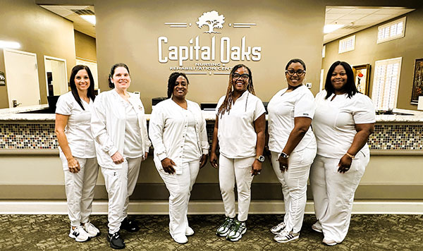 Group of nurses in front of lobby desk.