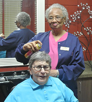 hair stylist styling elderly woman's hair